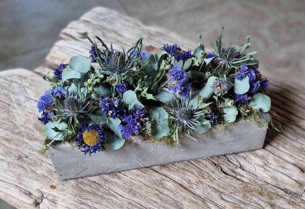 Trockenblumen: Gesteck in Blautöne, Kreation von fleurs-devie.ch – arrangement piqué de fleurs séchées dans les tons bleus, création de fleurs-devie.ch