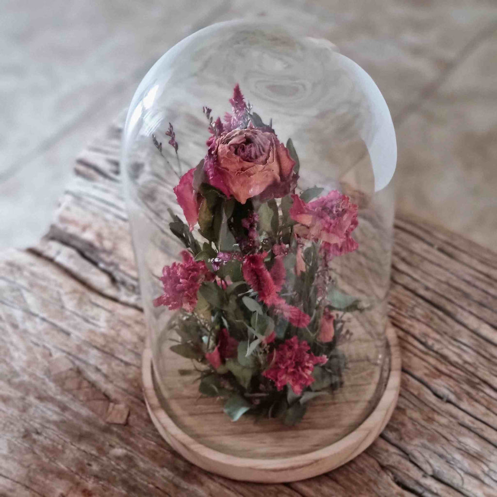 Trockenblumen : Glasglocke mit Trockenblumen in Rosatöne, Kreation von fleurs-devie.ch – fleurs séchées : cloche en verre avec des séchées dans les tons roses, création de fleurs-devie.ch